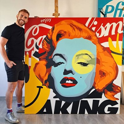 Javier Andrés sosteniendo el lienzo Enjoy King